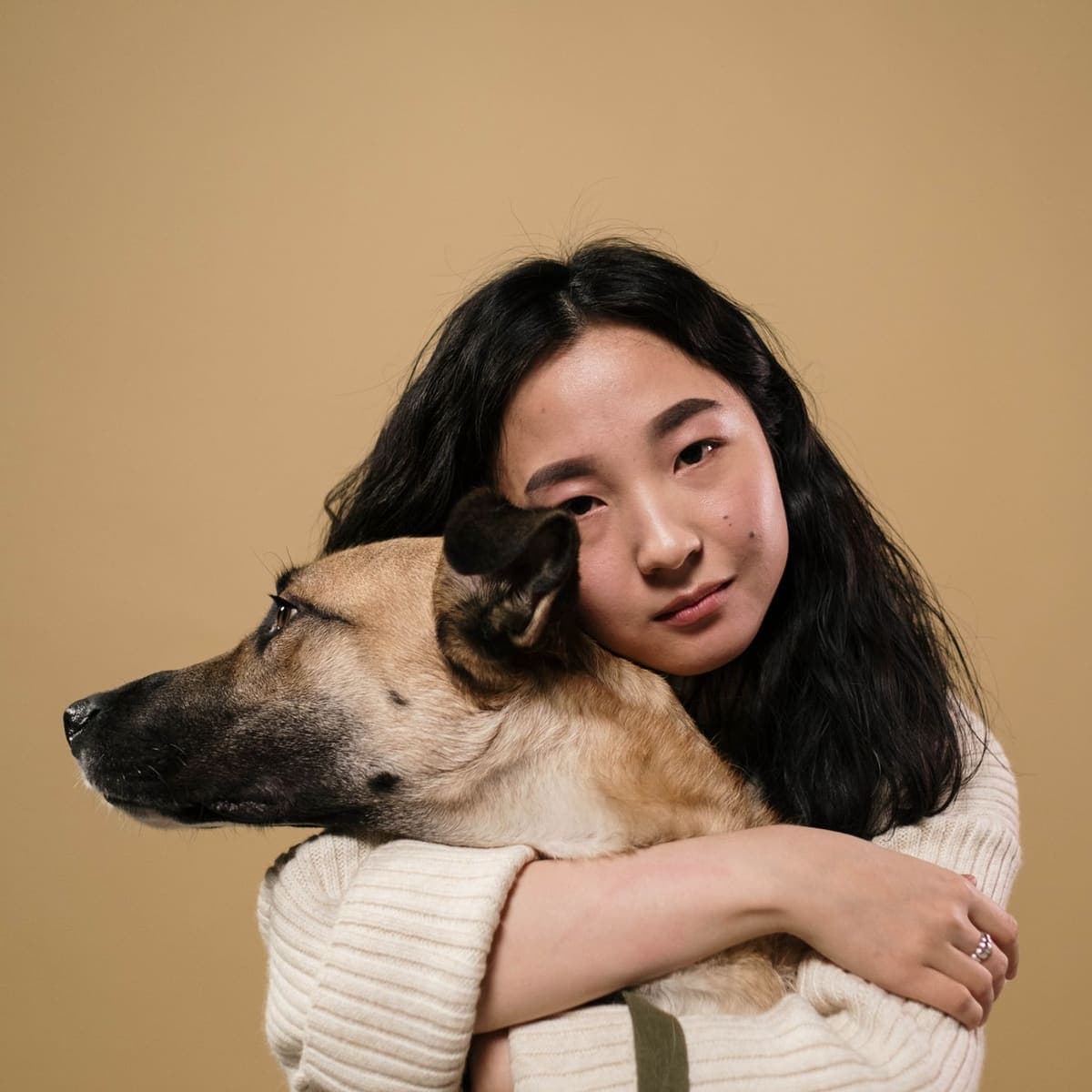 A person holding their dog close, both looking calm.